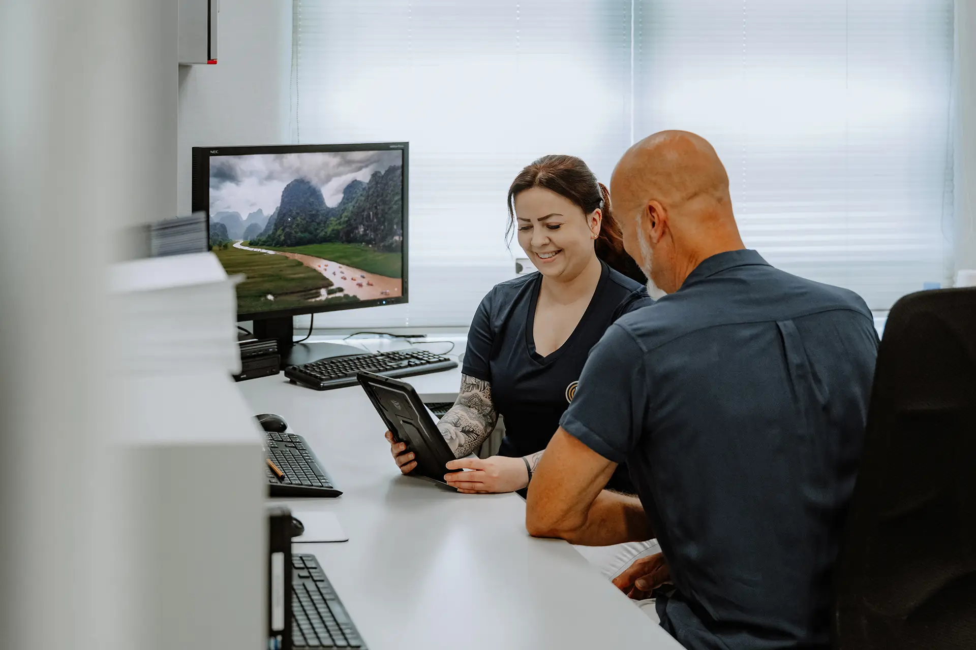 Medizinische Fachangestellte im Gespräch mit einem Patienten vor einer CT-Untersuchung.