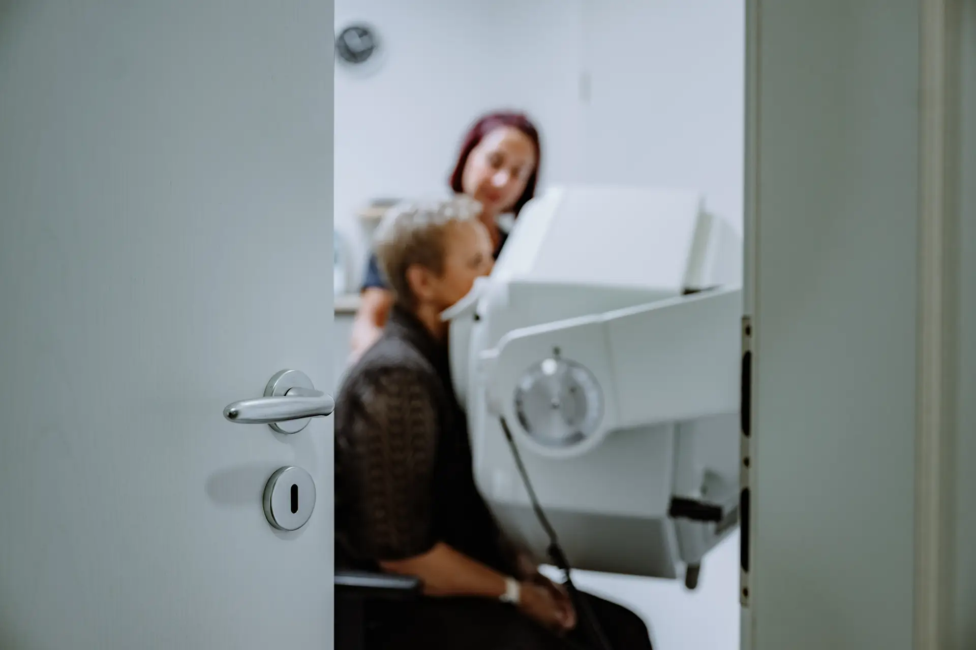 Patientin wird von einer medizinischen Fachangestellten für eine nuklearmedizinische Untersuchung an der Gammakamera positioniert.