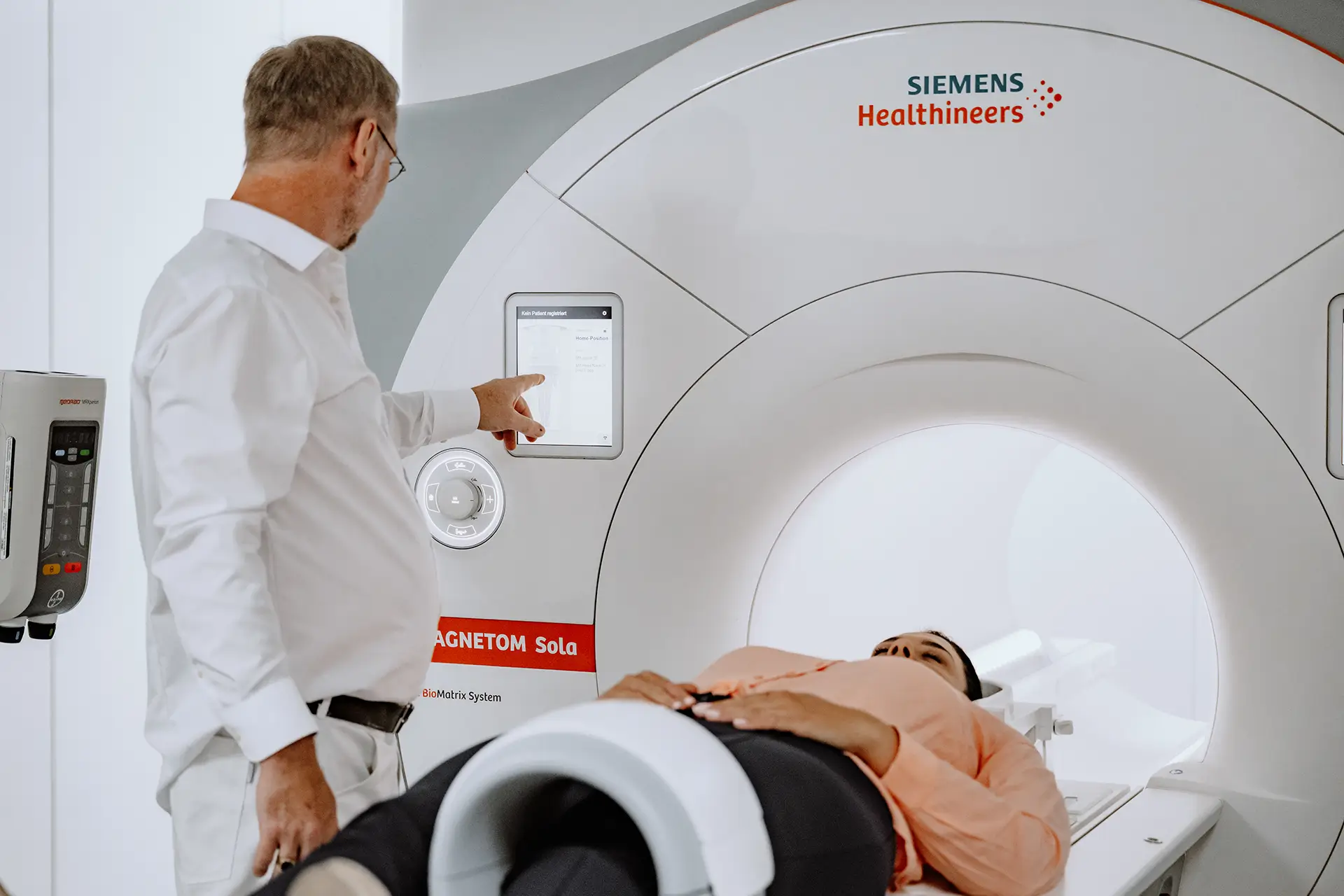 Arzt bedient das Siemens MAGNETOM Sola MRT-Gerät während der Vorbereitung einer Patientin.